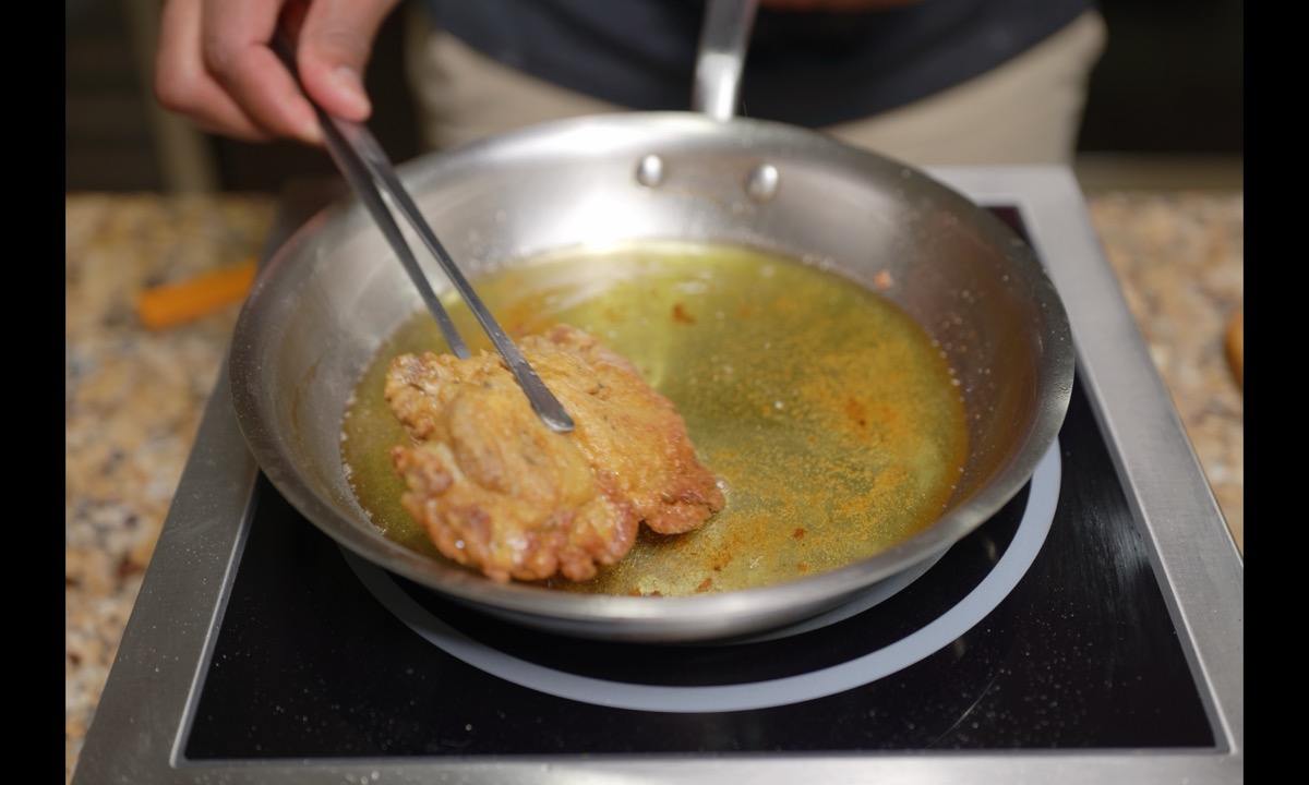 Coated oyster mushroom cluster frying in avocado oil