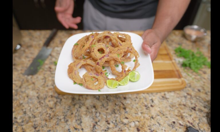 Plate of crispy kamut double-dredged red onion rings with key lime wedges