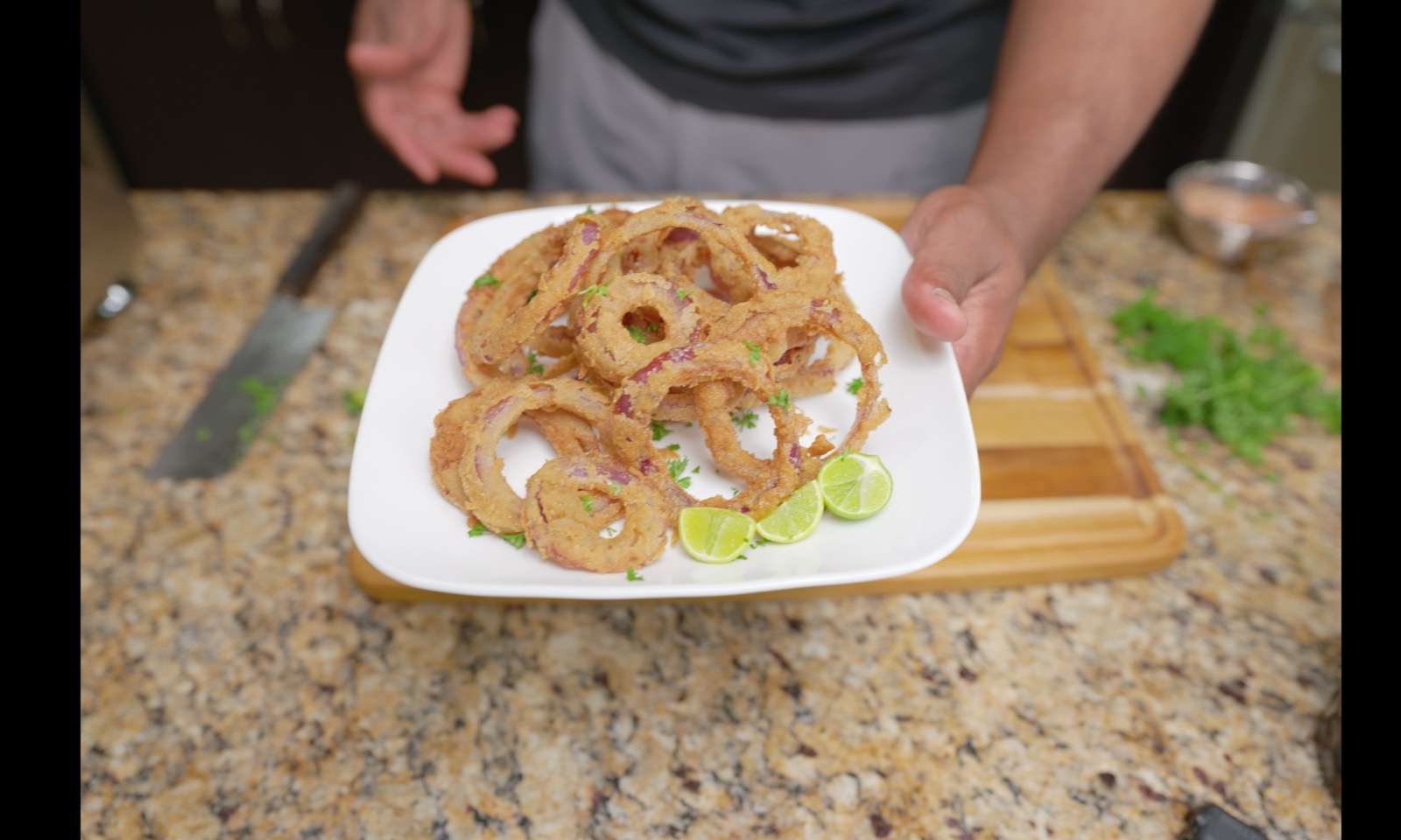 Plate of crispy kamut double-dredged red onion rings with key lime wedges