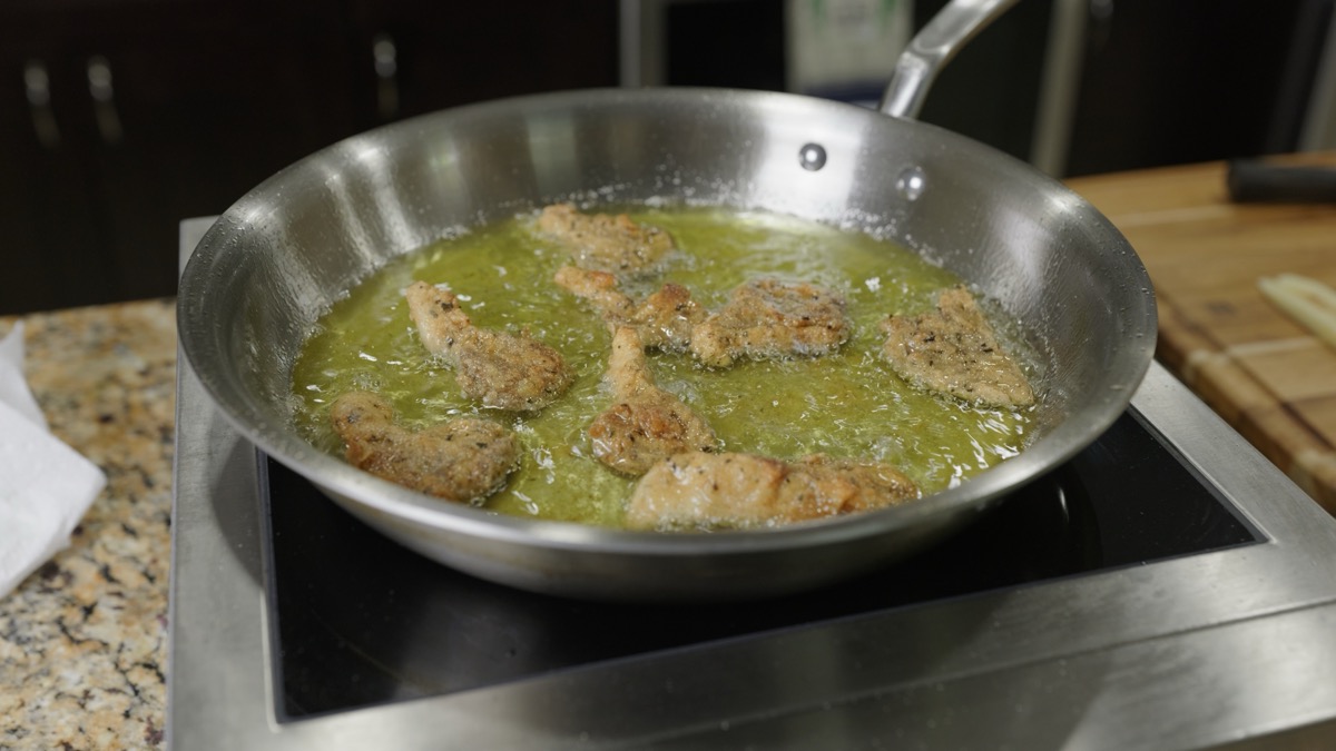 Seasoned oyster mushroom pieces frying golden in grapeseed oil